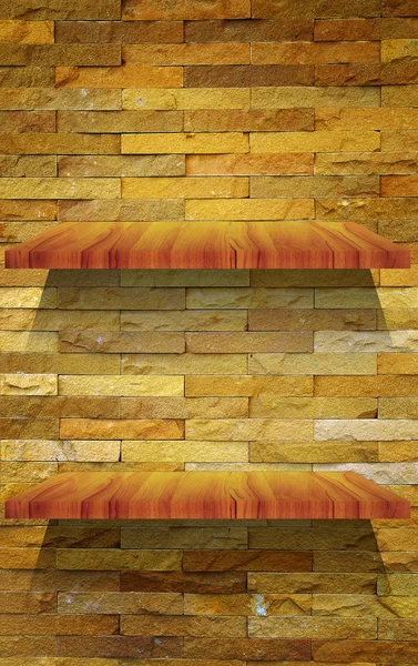 Prázdné dřevěné police na kamenné zdi — Stock fotografie
