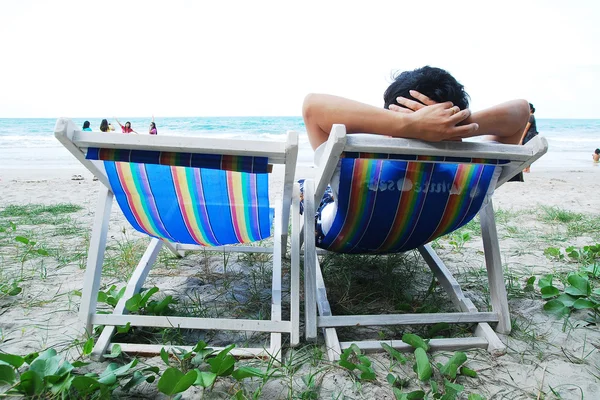 Homme relaxant dans une chaise de plage — Photo