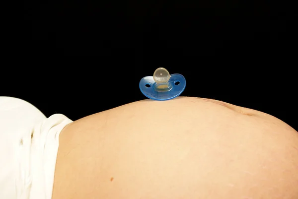 Maminky břicho a dudlík — Stock fotografie