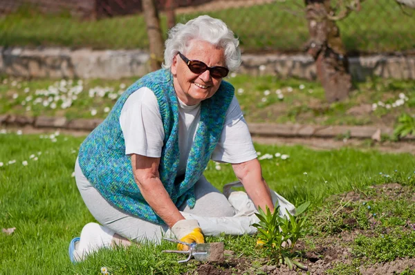 Starsza kobieta w ogrodzie — Zdjęcie stockowe