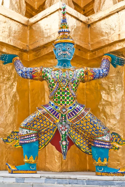 En jätte blå kroppen använda två händer bär en pagoda bas — Stockfoto