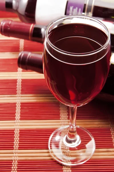 Κρασί σε ποτήρι με μπουκάλια — Φωτογραφία Αρχείου