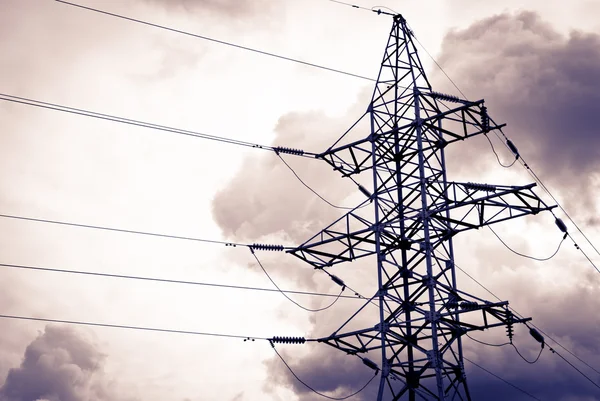 Электрический столб высокой мощности в облачный день с силуэтом — стоковое фото