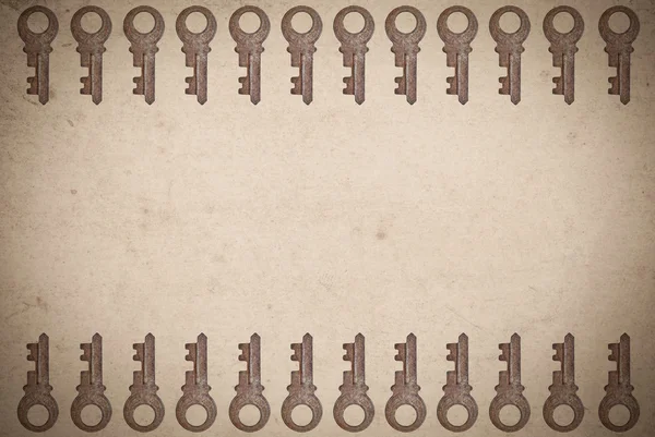 Ржавые ключи на старом бумажном фоне — стоковое фото