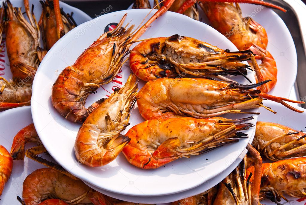 Flame grilled large prawns on white plates