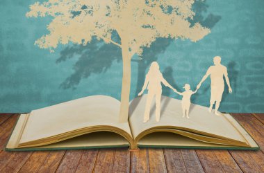 Paper cut of family symbol under tree on old book clipart