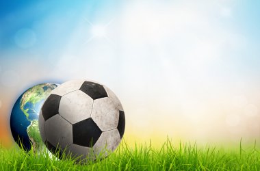 Futbol topu ve toprak yeşil çimenlerin üzerinde