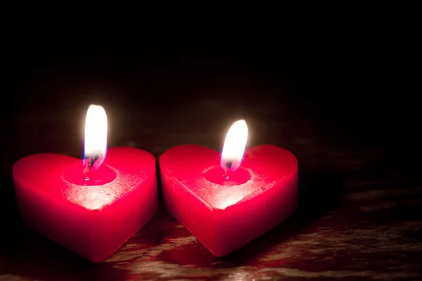 Velas vermelhas em forma de coração ardente — Fotografia de Stock