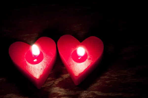 Velas vermelhas em forma de coração ardente — Fotografia de Stock