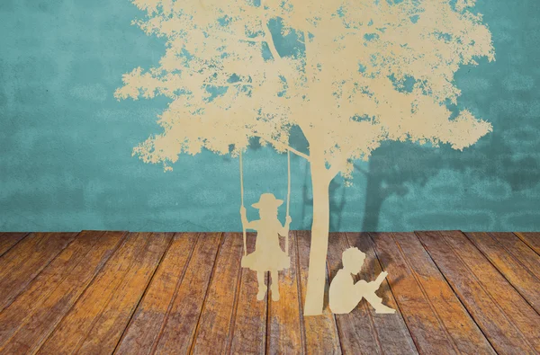 Детская вырезка из бумаги читает книгу под деревом — стоковое фото