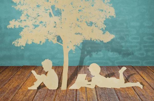 O corte de papel de crianças lê um livro abaixo da árvore — Fotografia de Stock