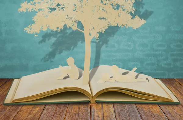 Papierschnitt von Kindern liest ein Buch — Stockfoto