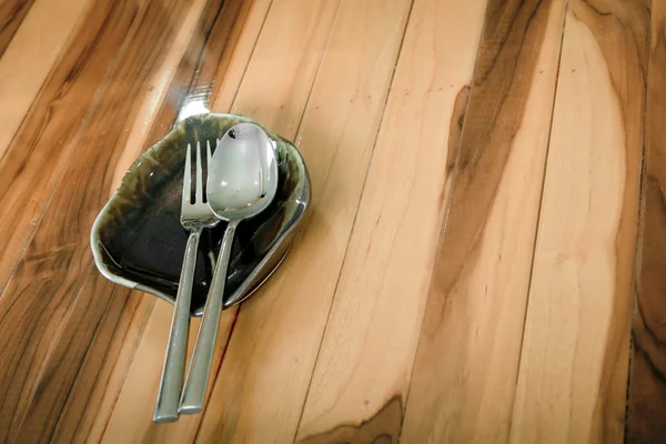 Assiette, couteau et fourchette vides sur table en bois — Photo