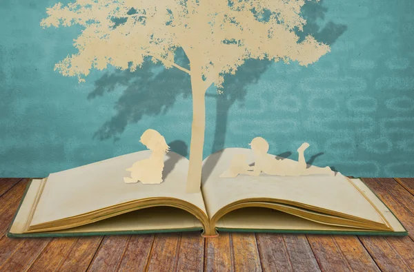 古い本の木の下で本を読む子供のカット紙 — ストック写真