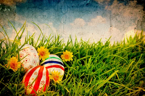 Grunge papper med påskägg och blomma på färskt grönt gräs ov — Stockfoto