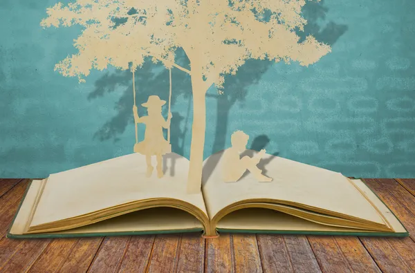 El corte de papel de los niños leen el libro y los niños en el columpio bajo tr — Foto de Stock