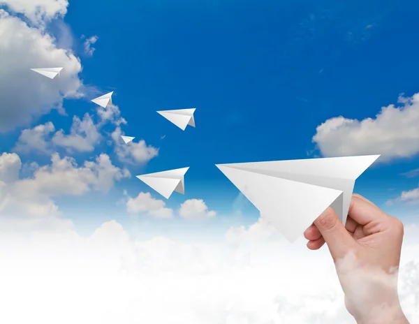 Hand throwing a paper plane in the sky — Stock Photo, Image