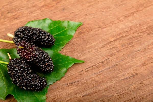 Mulberry och blad på gammalt trä — Stockfoto