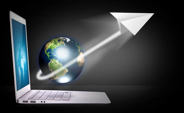 Laptop met aarde en papier vliegtuig — Stockfoto