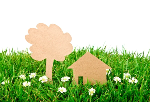 Papier gesneden van huis en boom op verse lente groen gras — Stockfoto