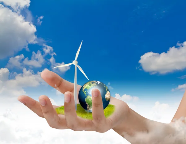 Turbinas eólicas e terra na mão sobre o céu azul — Fotografia de Stock