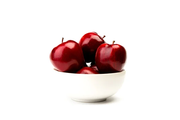 Красное яблоко на белой тарелке на белом фоне — стоковое фото