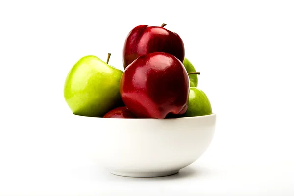 Зеленый и красный яблоко на тарелке изолированы на белом фоне — стоковое фото