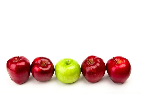 Mela verde tra mele rosse isolate su un bianco — Foto Stock