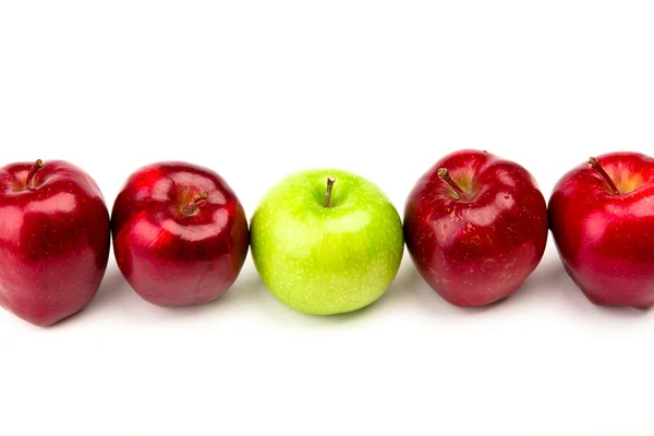 Πράσινο μήλο μεταξύ κόκκινα μήλα απομονωμένη σε ένα λευκό — Φωτογραφία Αρχείου