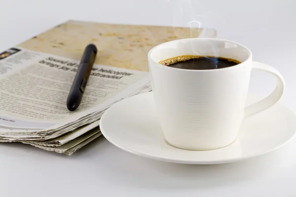 A cup of coffee and a newspaper — Stock Photo, Image