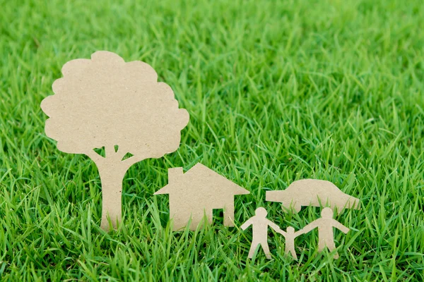 Papierschnitt einer Familie mit Haus, Baum und Auto auf frischem Frühlingsgras — Stockfoto