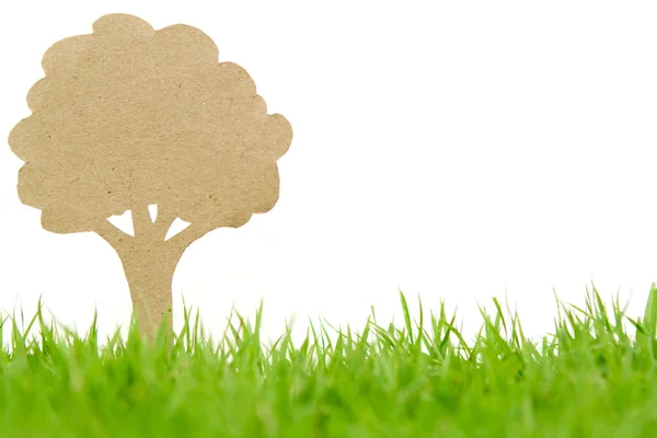 Paper cut of tree on fresh spring green grass — Stock Photo, Image