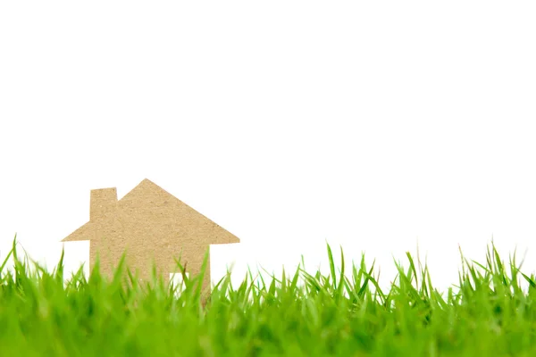 Papír řez domu na svěží jarní zelené trávě — Stock fotografie