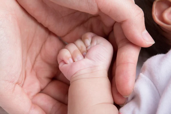 Female hand holding newborn baby hand — Stock Photo, Image
