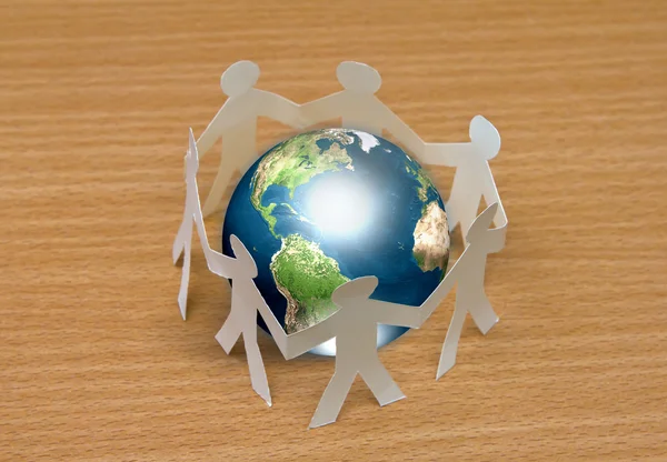 Paper cut of standing in a circle around globe on wooden — Stock Photo, Image
