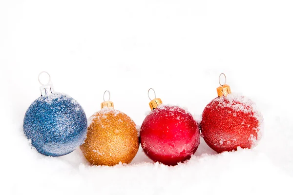 Bolas de Navidad azules, rojas y doradas con nieve —  Fotos de Stock