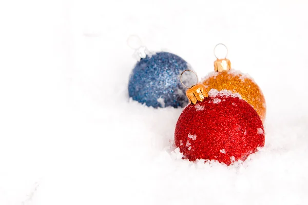 Boules de Noël bleues, rouges et dorées avec neige — Photo