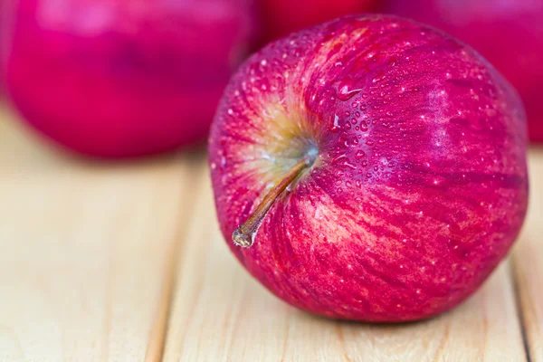Rote Äpfel auf Holztisch — Stockfoto