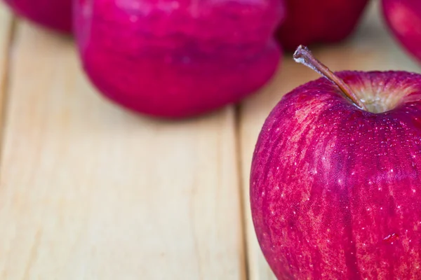 Röda äpplen på träbordet — Stockfoto