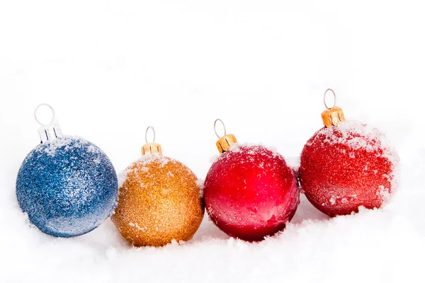 Blauwe, rode en gouden kerstballen met sneeuw — Stockfoto