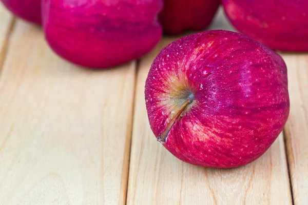 Rote Äpfel auf Holztisch — Stockfoto