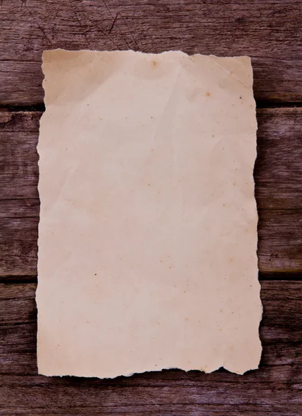 Старая бумага на коричневом дереве — стоковое фото