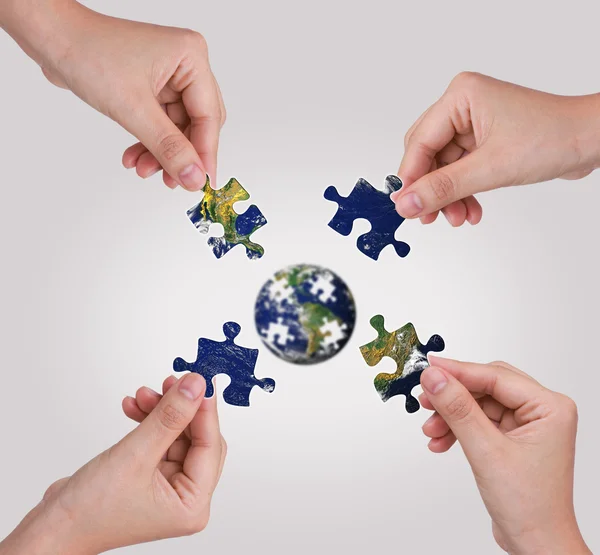 Geschäftskonzept mit einem Hand Building Puzzle Globus — Stockfoto
