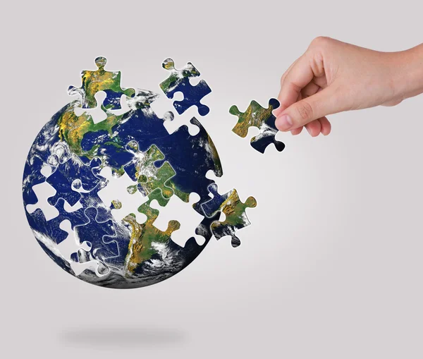 Businessconcept met een hand gebouw puzzel globe — Stockfoto