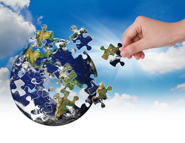 Business concept with a hand building puzzle globe — Stock Photo, Image
