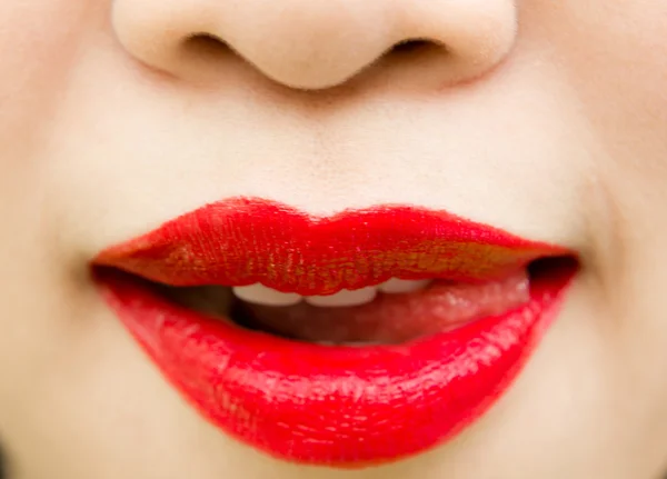 Primer plano de los labios de la mujer con lápiz labial rojo brillante — Foto de Stock