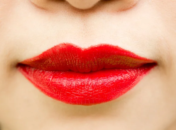 Крупный план женских губ с глянцевой красной помадой — стоковое фото
