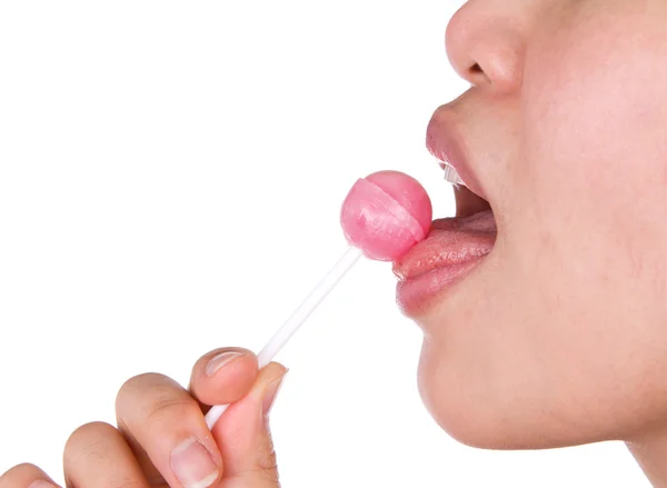 白地にピンクの光沢のあるロリポップを舐めている女性. — ストック写真