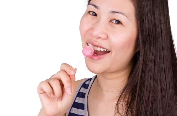 Woman licking a pink shiny lollipop on white background. — Stock Photo, Image