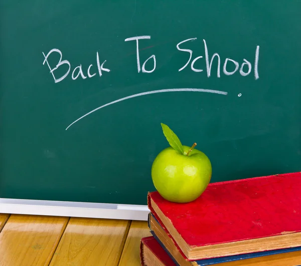 Zurück zur Schule geschrieben auf Kreidetafel mit grünem Apfel und Büchern — Stockfoto